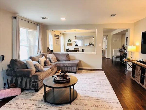 a living room with furniture and a wooden floor