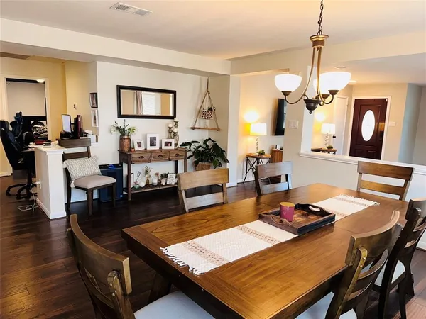 a living room with dining table and a chandelier