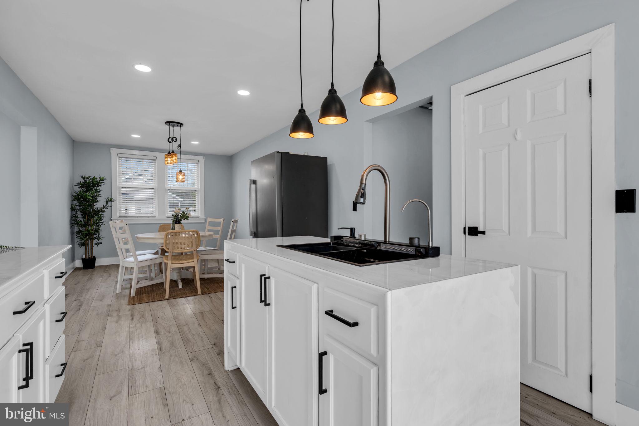 116 Hough Street Pemberton, NJ 08068 - Photo 11 of 25 a kitchen with stainless steel appliances a stove a sink a dining table and chairs with wooden floor