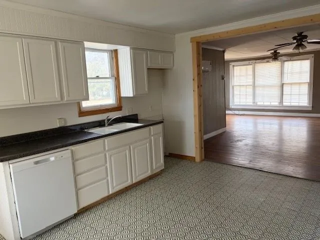 a kitchen with granite countertop white cabinets sink and window