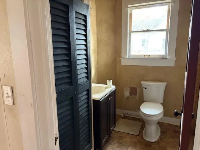 a bathroom with a toilet a sink and a window