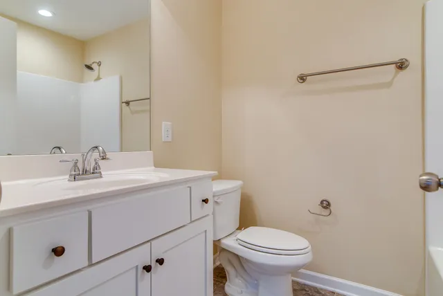 a bathroom with a sink a toilet and a mirror