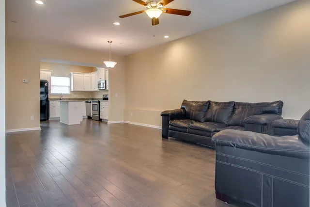 a living room with furniture and a wooden floor