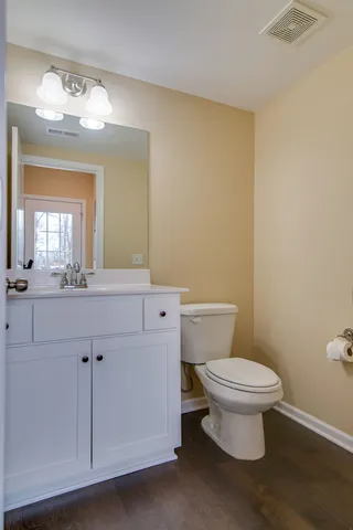 a bathroom with a toilet a sink and mirror