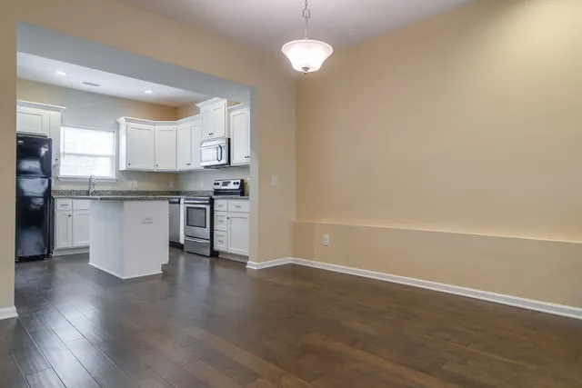 a view of kitchen with granite countertop cabinets and wooden floor