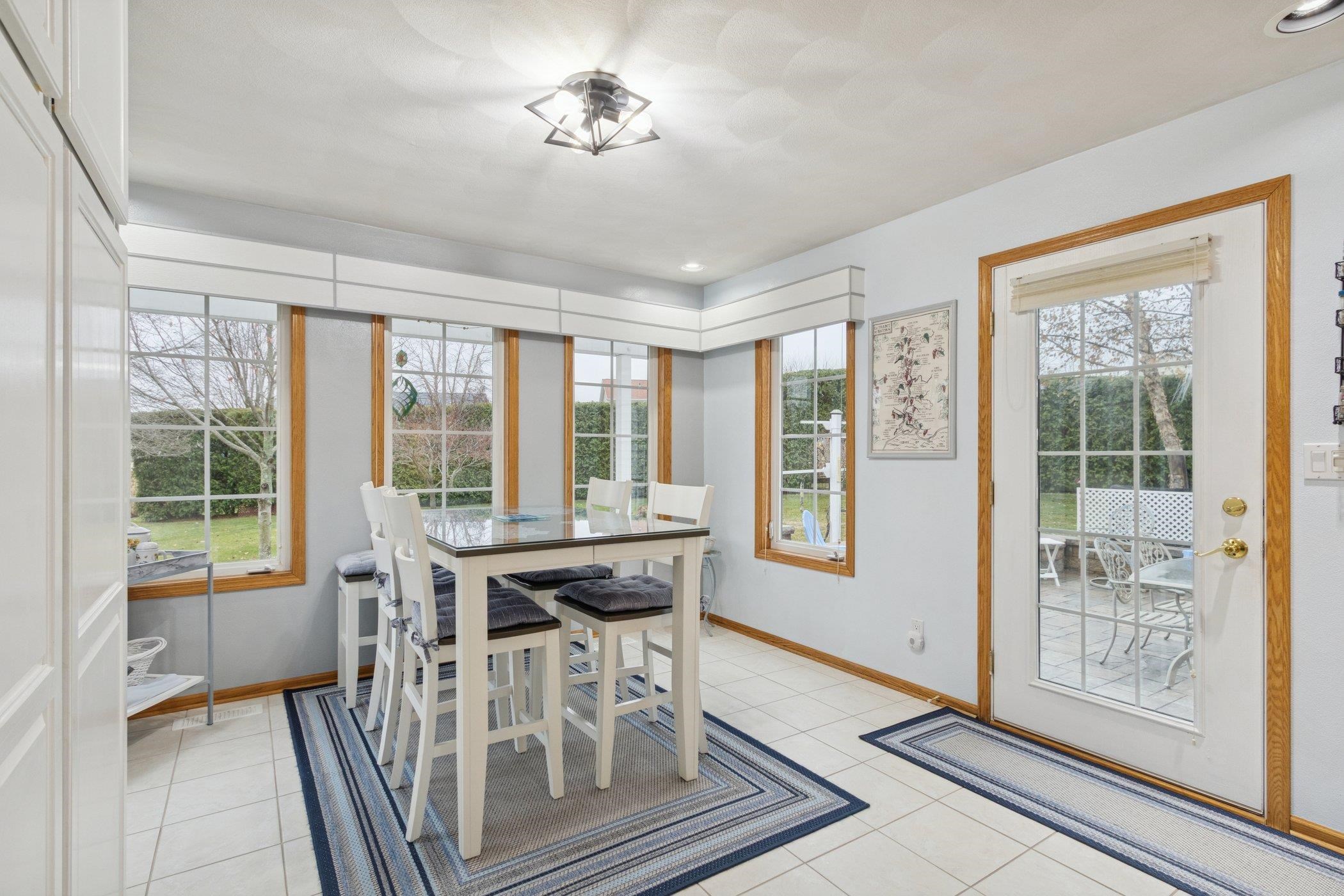 638 Merrion Road Roscoe, IL 61073 - Photo 60 of 64 a view of a dining room with furniture large windows and wooden floor