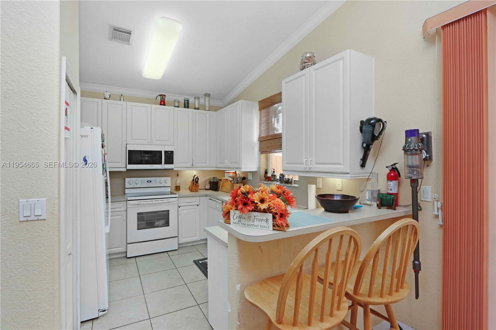 15382 Southwest 16th Terrace Miami, FL 33185 - Photo 9 of 26 a kitchen with stainless steel appliances a stove a sink dishwasher and white cabinets with wooden floor