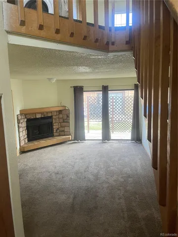 a view of an empty room with a fireplace and a window
