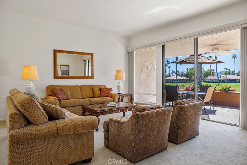 30 Haig Drive Rancho Mirage, CA 92270 - Photo 1 of 1 a living room with furniture a lamp and a floor to ceiling window