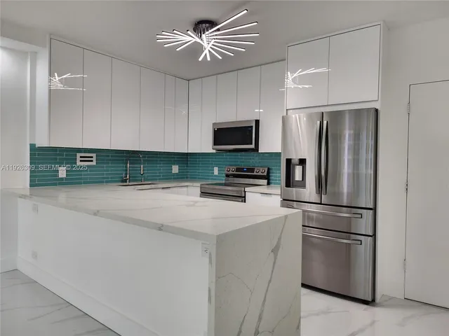 a kitchen with stainless steel appliances kitchen island granite countertop a refrigerator and microwave