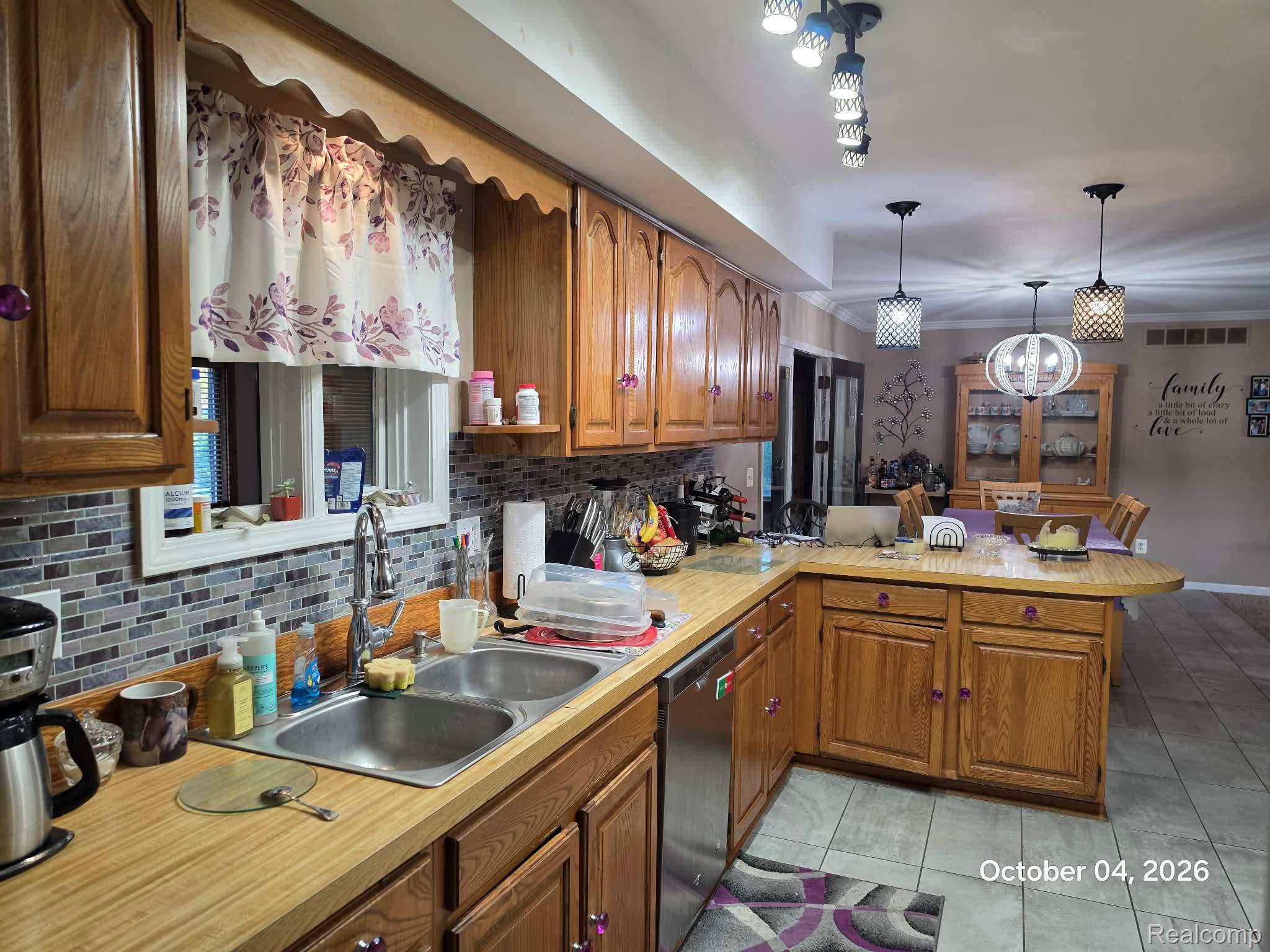 34781 Union Lake Road Clinton Township, MI 48035 - Photo 6 of 38 Tile flooring, wood-finish cabinetry, stainless steel dishwasher, dual basin sink, and a tiled backsplash