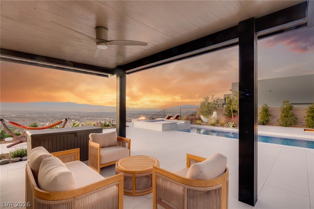 571 Overlook Rim Drive Henderson, NV 89012 - Photo 47 of 85 Patio terrace at dusk featuring a ceiling fan, a patio area, an outdoor living space, and a pool with connected hot tub