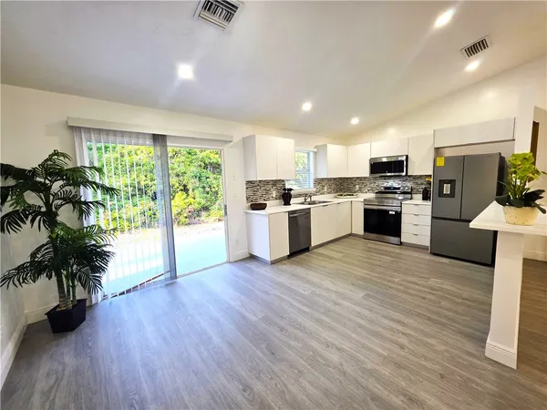 a kitchen with a stove top oven and refrigerator