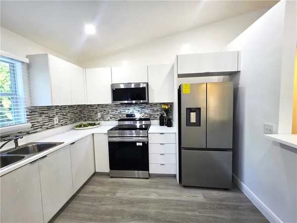 a kitchen with stainless steel appliances a refrigerator stove and sink