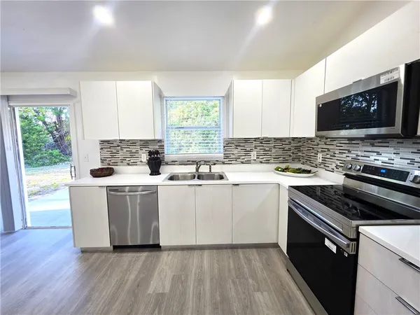 a kitchen with a stove a sink and a window