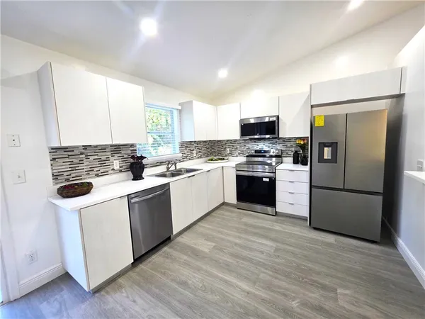 a kitchen with a white cabinets and white stainless steel appliances