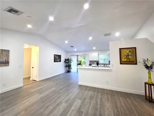 a view of a kitchen with wooden floor and a sink