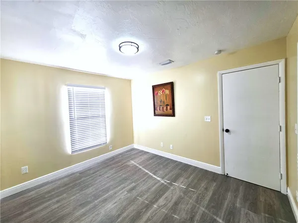 an empty room with windows and closet