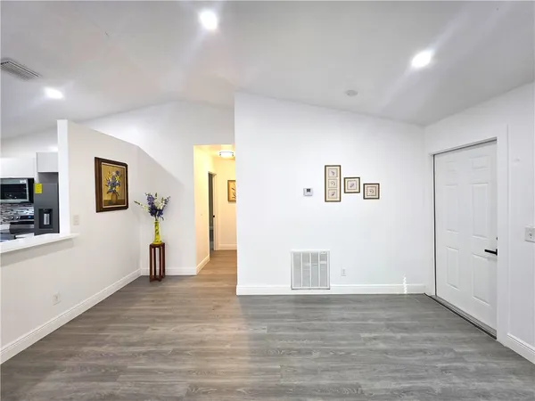 a view of a big room with wooden floor and windows
