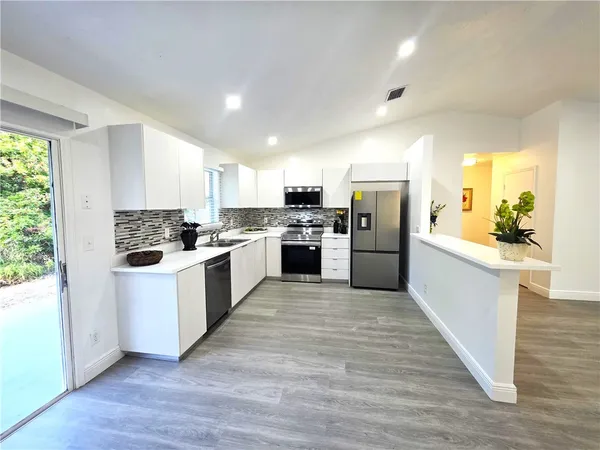 a kitchen with white cabinets and white appliances