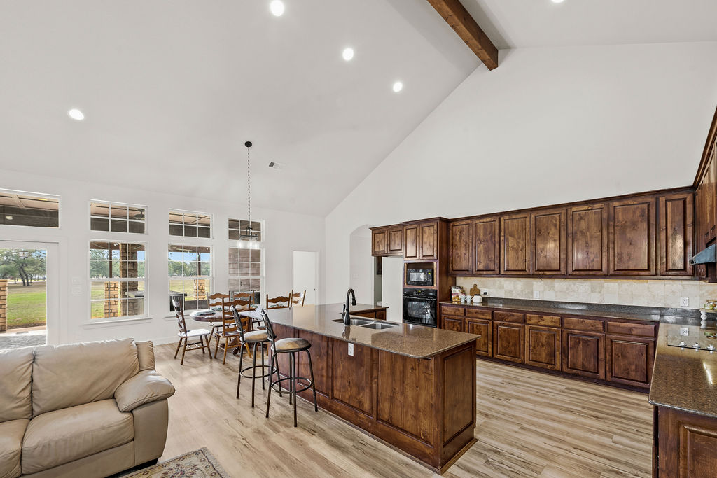 2795 Highway 290 Dripping Springs, TX 78620 - Photo 5 of 40 a kitchen with stainless steel appliances granite countertop a stove a sink dishwasher a couches with wooden floor and cabinets