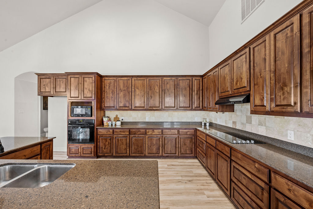 2795 Highway 290 Dripping Springs, TX 78620 - Photo 6 of 40 a kitchen with stainless steel appliances granite countertop a stove and cabinets
