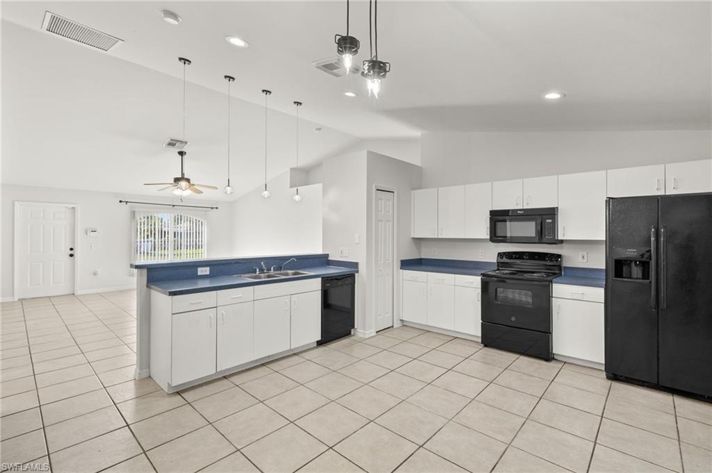 18396 Heather Road Fort Myers, FL 33967 - Photo 5 of 26 a kitchen with granite countertop a stove top oven cabinets and stainless steel appliances
