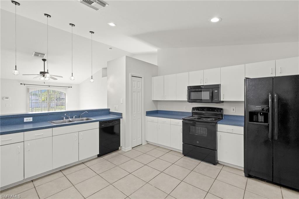 18396 Heather Road Fort Myers, FL 33967 - Photo 7 of 26 a kitchen with stainless steel appliances granite countertop a stove a sink and a refrigerator