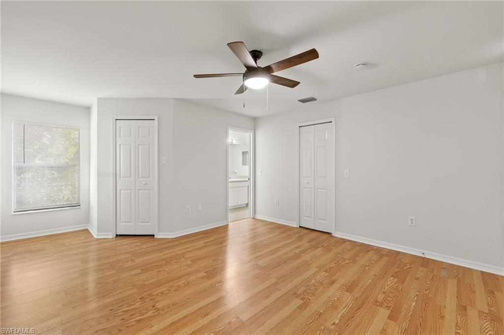 18396 Heather Road Fort Myers, FL 33967 - Photo 9 of 26 a view of an empty room with wooden floor and a ceiling fan