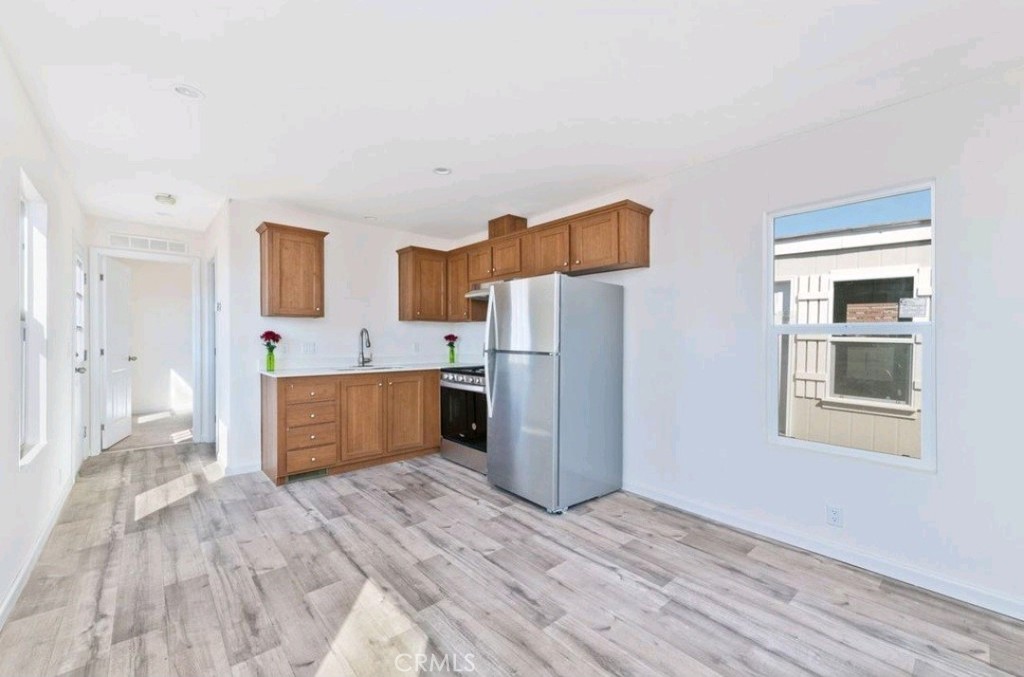 15252 Seneca Road, Unit 13 Victorville, CA 92394 - Photo 3 of 9 a kitchen with stainless steel appliances kitchen island wooden cabinets and entryway