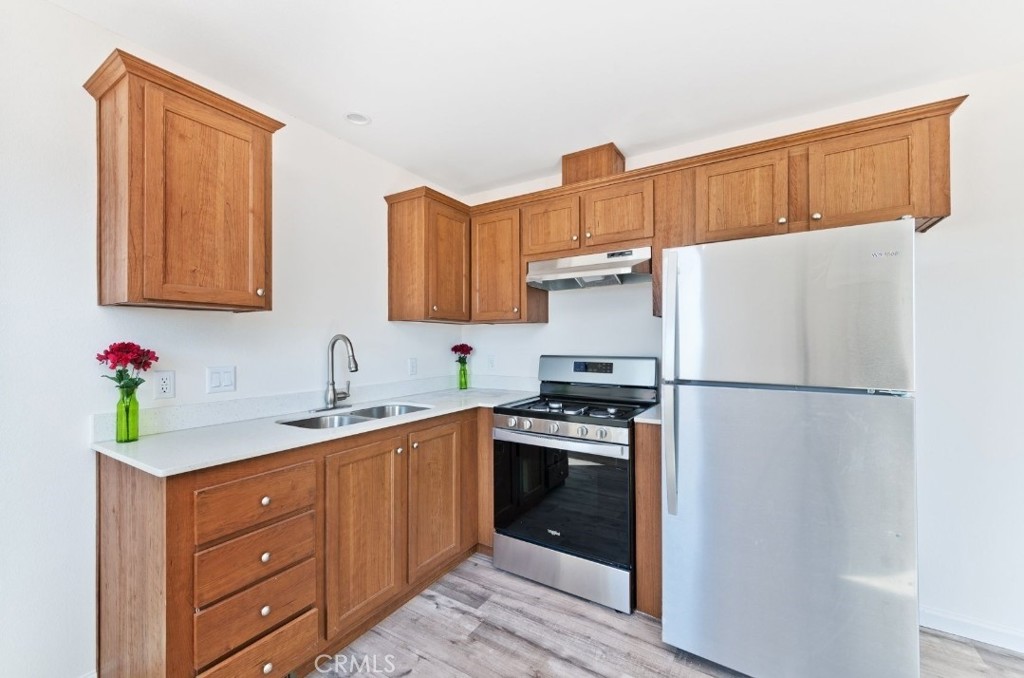 15252 Seneca Road, Unit 13 Victorville, CA 92394 - Photo 4 of 9 a kitchen with a sink stainless steel appliances and cabinets