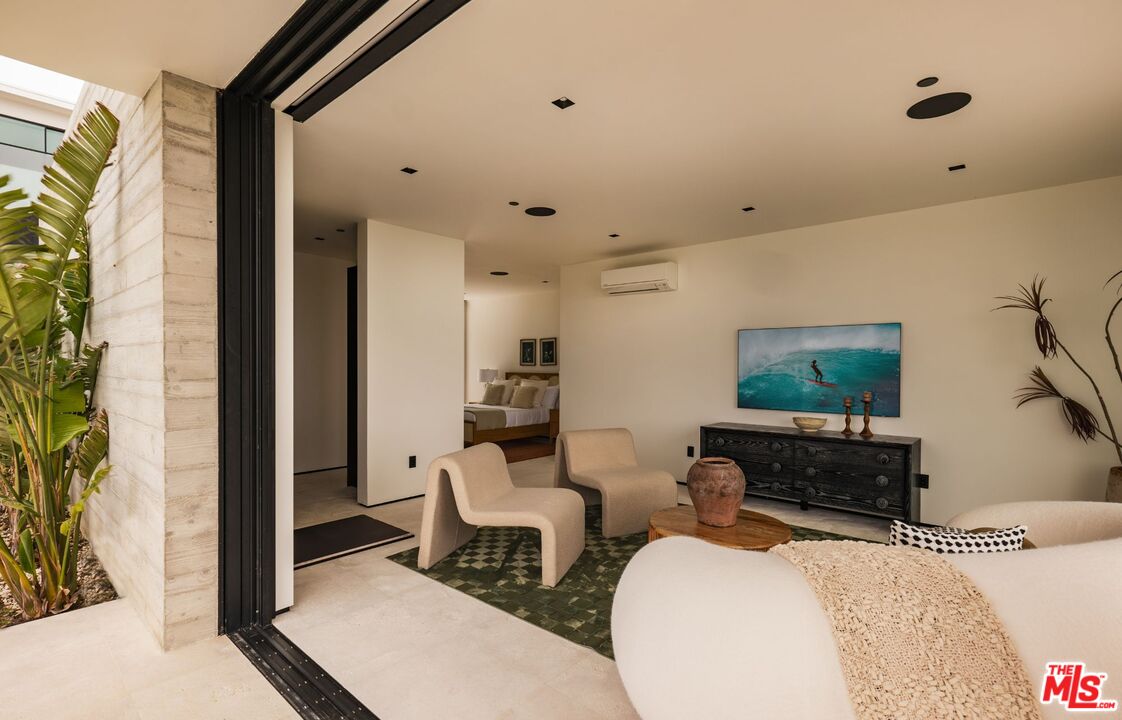6889 Dume Drive Malibu, CA 90265 - Photo 29 of 41 a living room with furniture a rug and a painting on the wall
