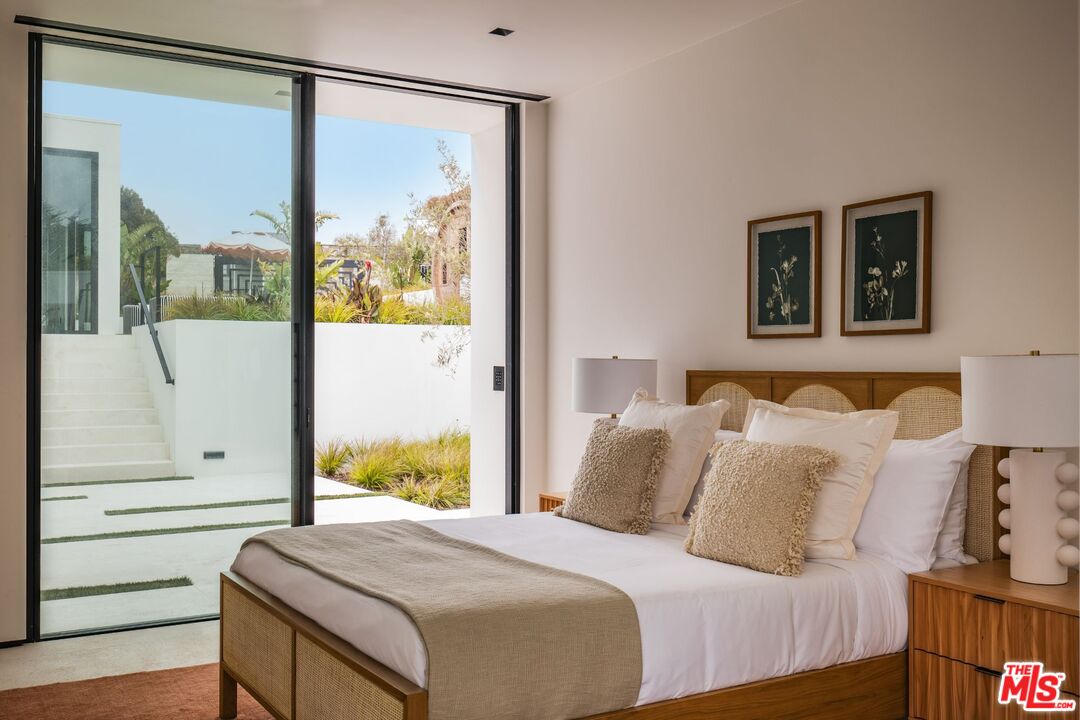 6889 Dume Drive Malibu, CA 90265 - Photo 30 of 41 a bedroom with a bed and a painting on the wall