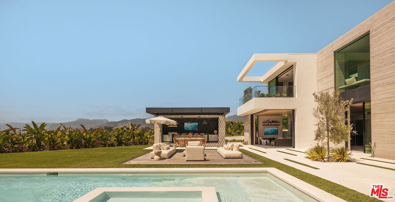 6889 Dume Drive Malibu, CA 90265 - Photo 33 of 41 a view of a patio with table and chairs potted plants with floor to ceiling window