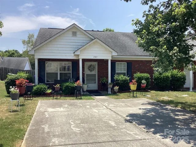 a front view of a house with yard and potted plants