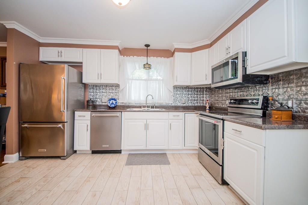1461 Rodman Street Fall River, MA 02721 - Photo 23 of 40 a kitchen with stainless steel appliances a refrigerator sink and microwave