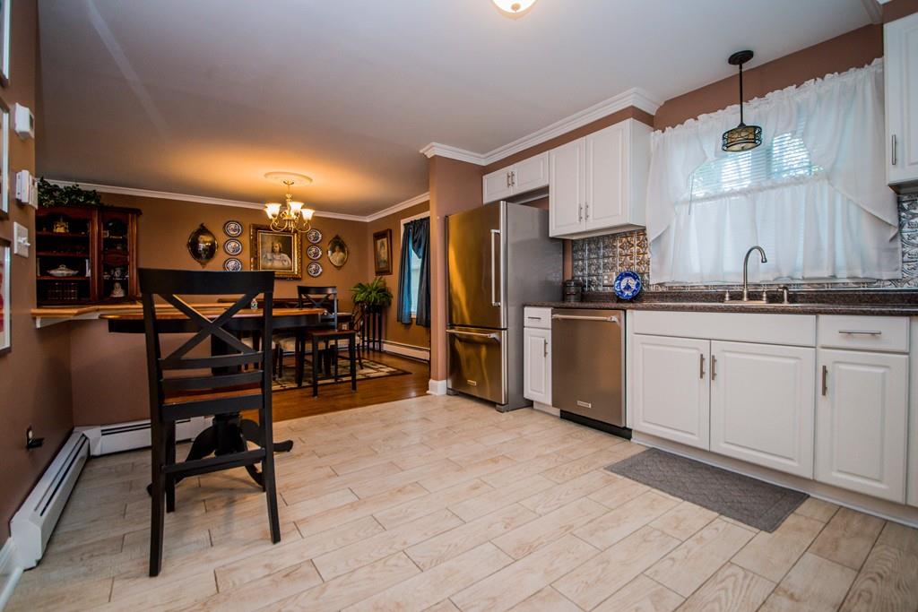 1461 Rodman Street Fall River, MA 02721 - Photo 24 of 40 a kitchen with stainless steel appliances kitchen island granite countertop dining table chair and cabinets