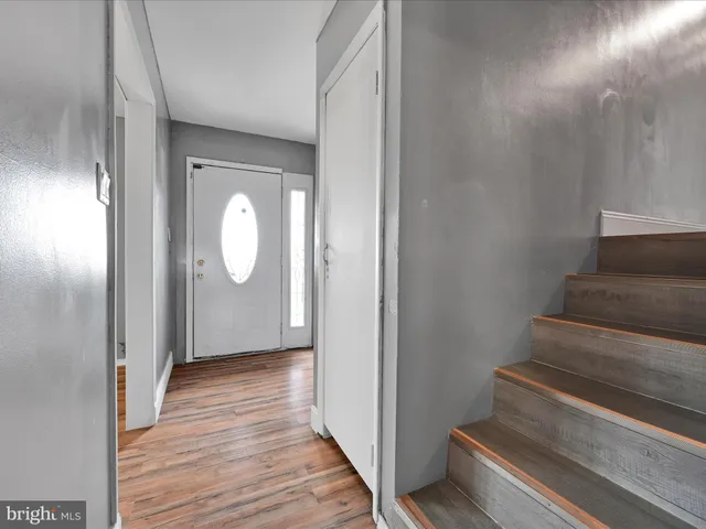 a view of a hallway with wooden floor and staircase