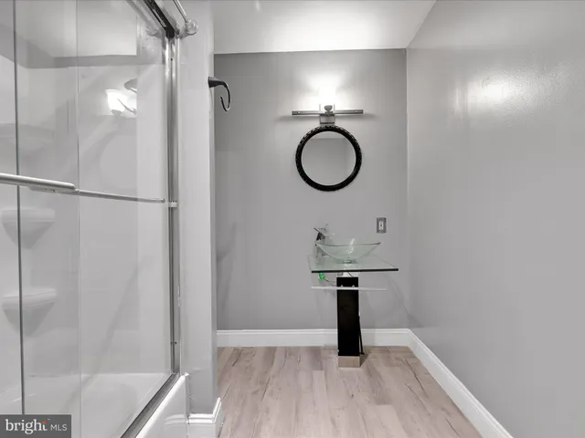 a bathroom with a sink a light fixture and a mirror