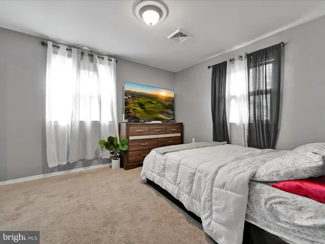 a bedroom with a bed and large windows