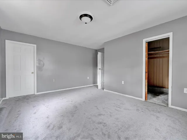 a view of an empty room and closet area
