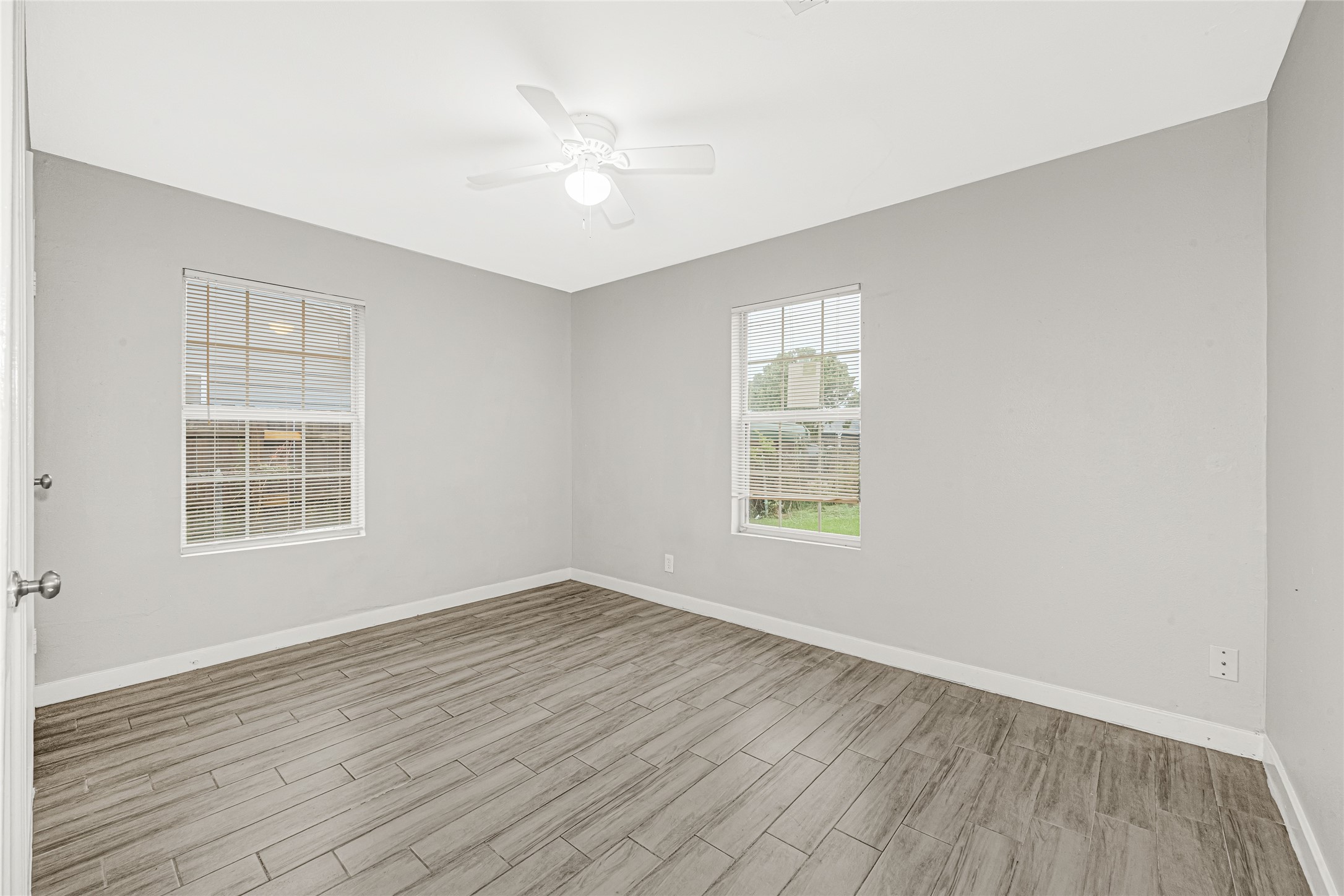 5009 Bataan Road Houston, TX 77033 - Photo 18 of 24 an empty room with wooden floor and windows