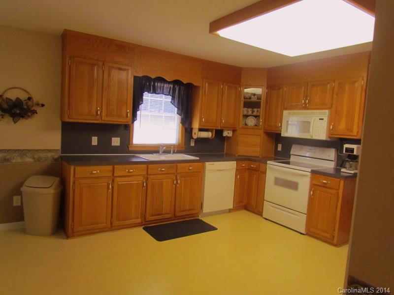 7858 Cheatham Ford Road Hiddenite, NC 28636 - Photo 13 of 24 a kitchen with white cabinets and white appliances