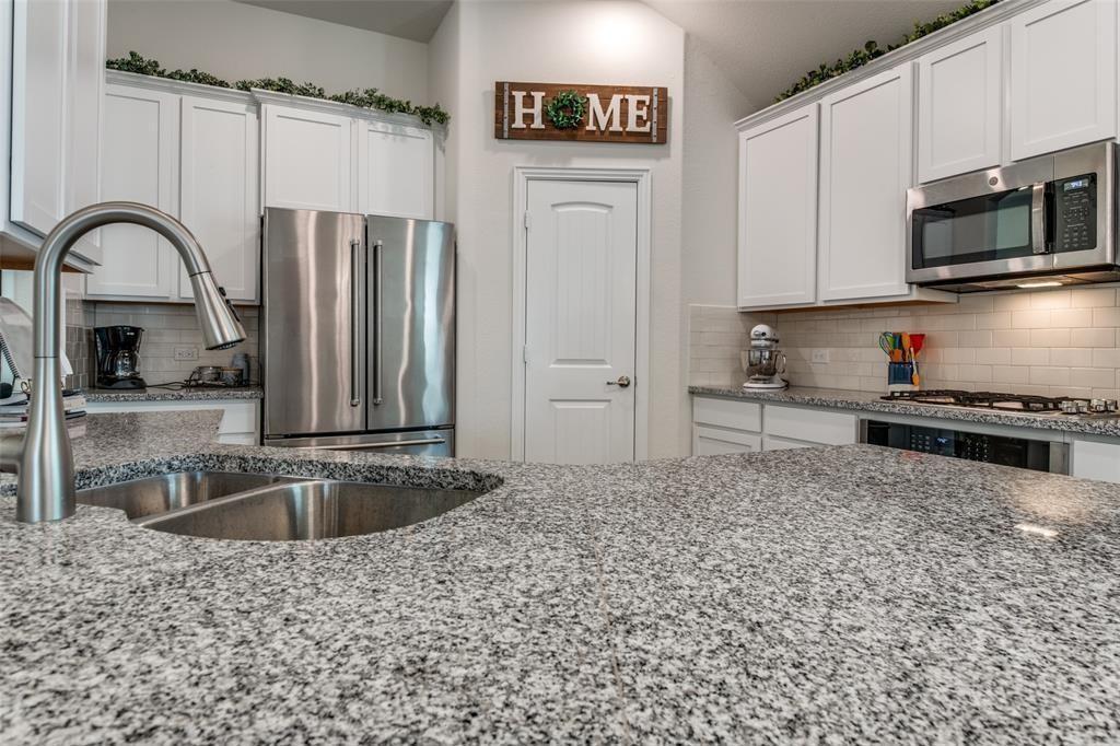 14845 Gilley Lane Fort Worth, TX 76052 - Photo 22 of 35 a kitchen with a refrigerator a stove a sink and a microwave