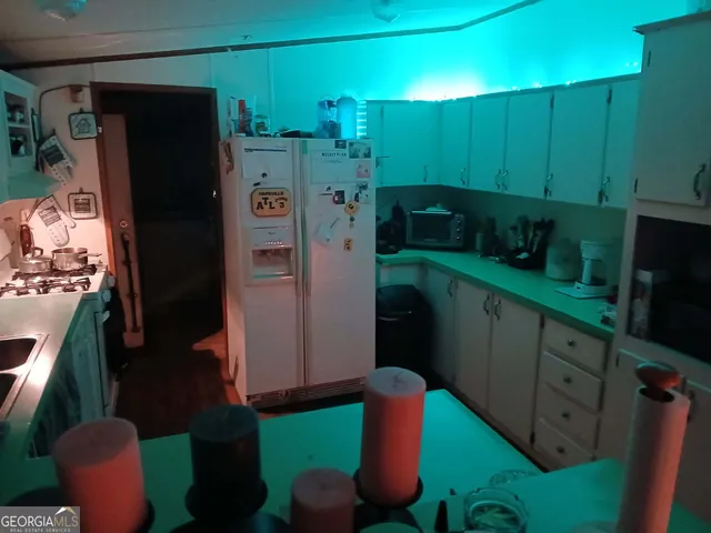 a kitchen with stainless steel appliances granite countertop a refrigerator and a wooden fence