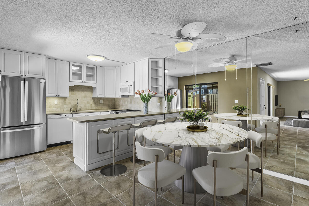 6025 Southeast Riverboat Drive, Unit 811 Stuart, FL 34997 - Photo 11 of 37 a kitchen with granite countertop a center island and stainless steel appliances