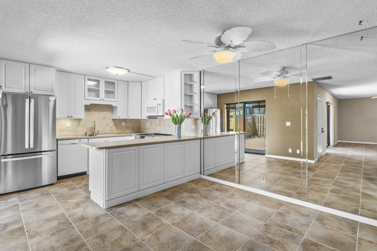 6025 Southeast Riverboat Drive, Unit 811 Stuart, FL 34997 - Photo 12 of 37 a kitchen with refrigerator and cabinets