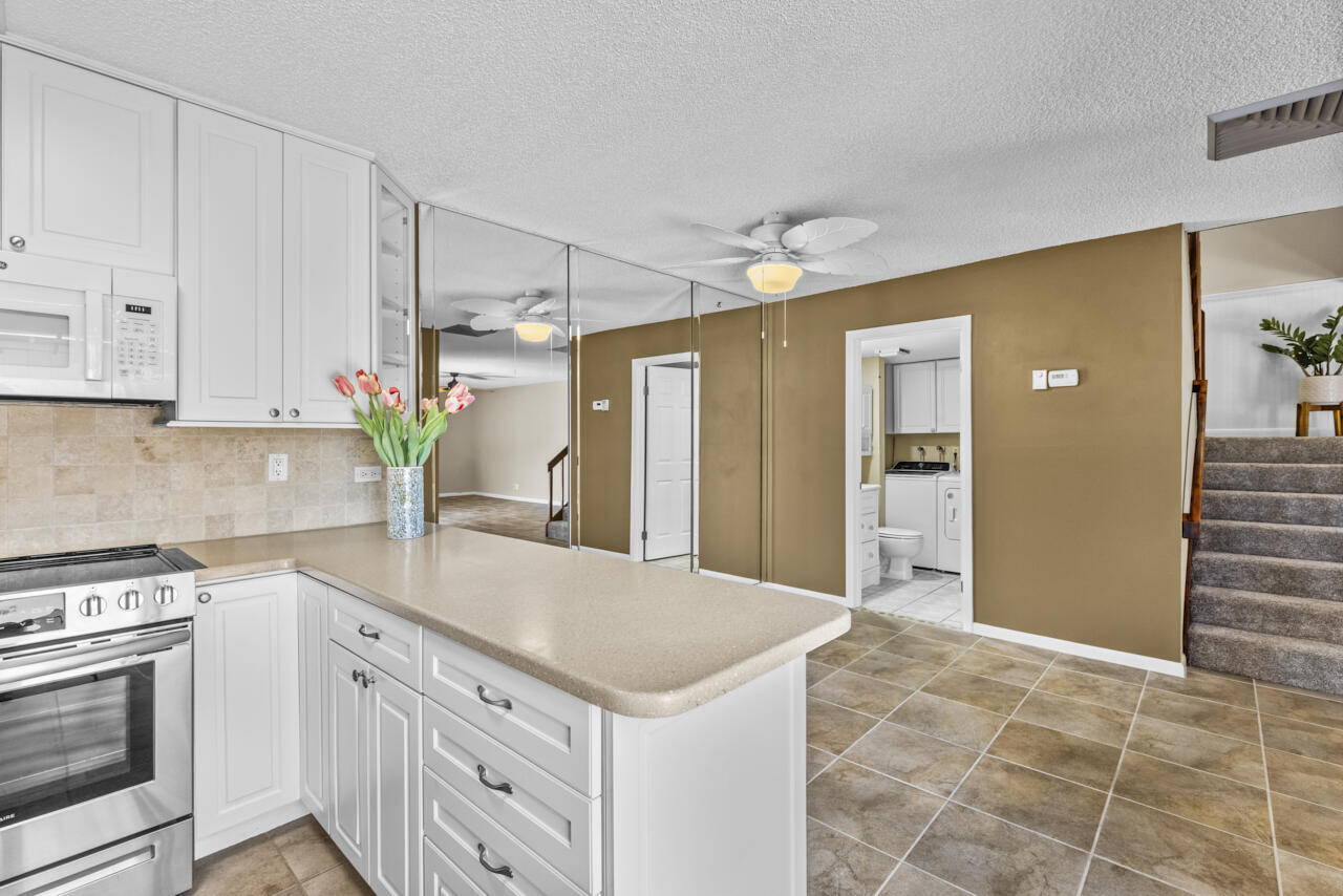 6025 Southeast Riverboat Drive, Unit 811 Stuart, FL 34997 - Photo 15 of 37 a kitchen with a stove a sink and a refrigerator