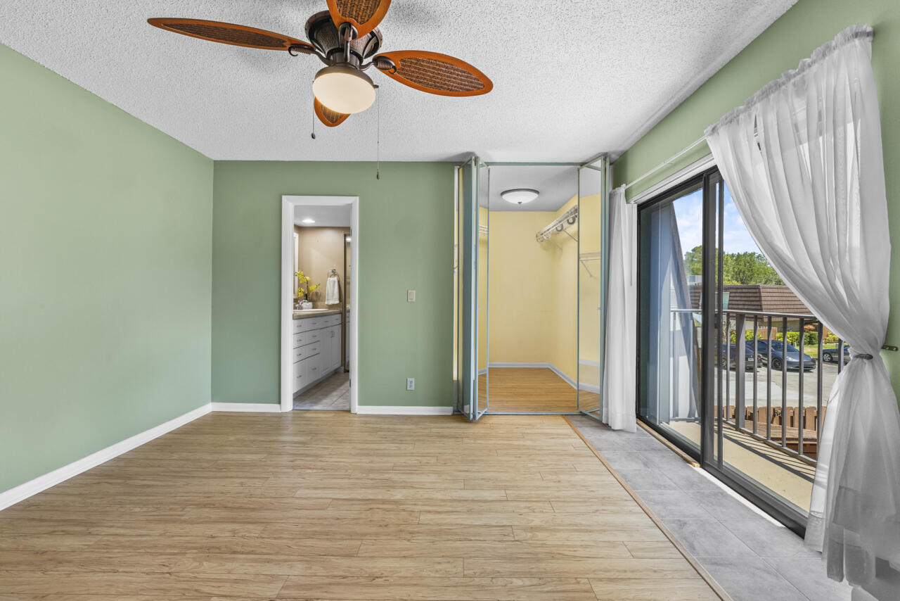 6025 Southeast Riverboat Drive, Unit 811 Stuart, FL 34997 - Photo 19 of 37 a view of a room with wooden floor fan and windows