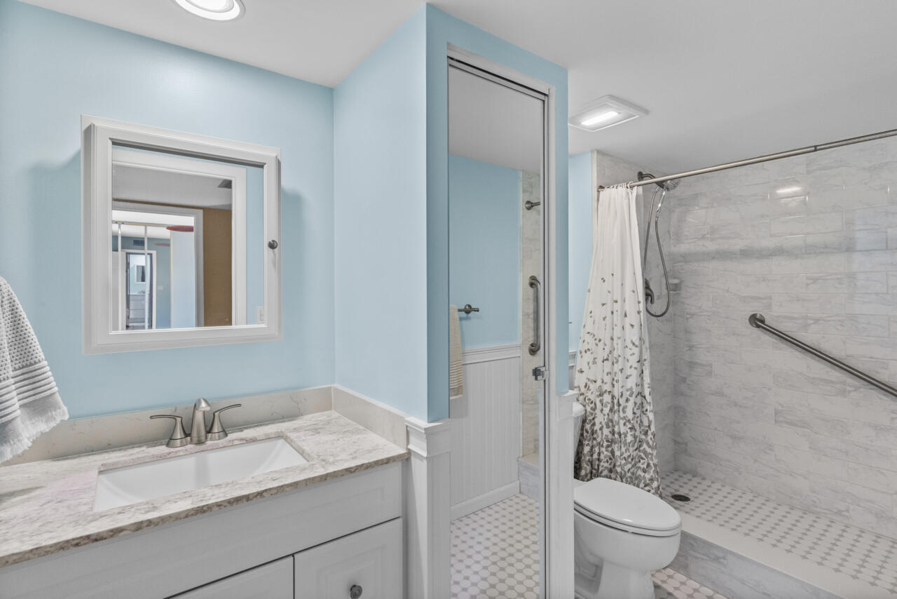 6025 Southeast Riverboat Drive, Unit 811 Stuart, FL 34997 - Photo 27 of 37 a bathroom with a granite countertop sink toilet and shower